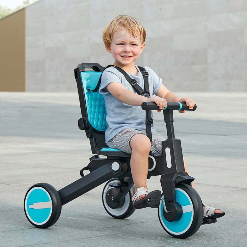 Child riding a Newtronx Trixplorer tricycle on a nature trail