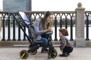 Parent and toddler with a Newtronx foldable toddler tricycle