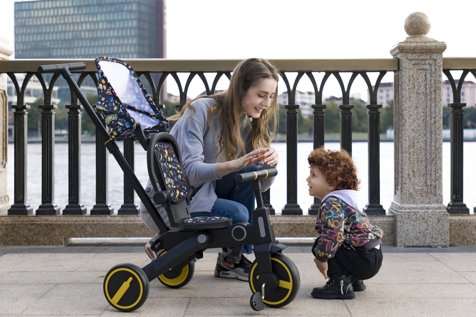Parent and toddler with a Newtronx foldable toddler tricycle